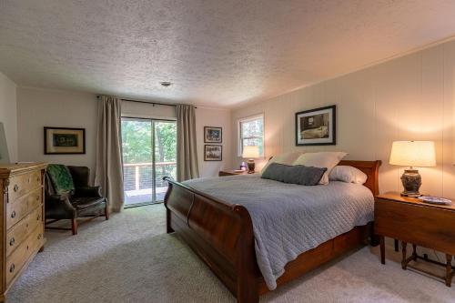 a bedroom with a bed and a dresser and a window at Elk Watch at Hound Ears in Valle Crucis