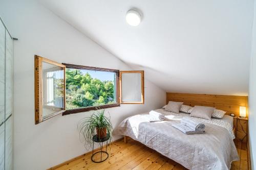 een slaapkamer met een bed en een raam bij Villa Tudor Mit Atemberaubender Aussicht in Bobovišća