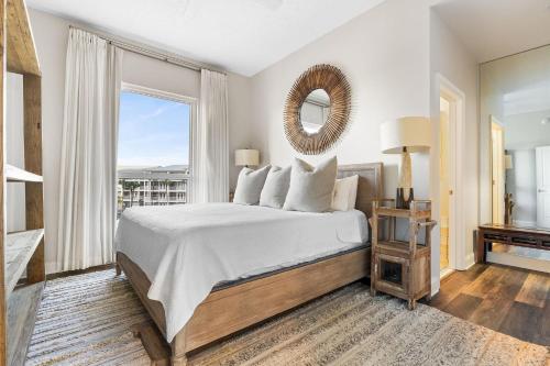 ein Schlafzimmer mit einem Bett mit Spiegel und Fenster in der Unterkunft La Playa 201 in Perdido Key