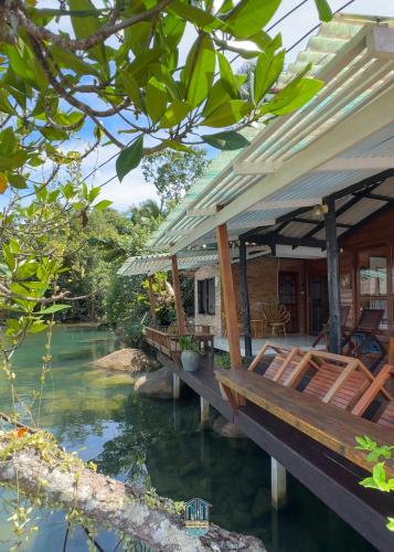 a house with a bridge over a river at คลองมาดโฮสเทลเกาะกูด Klongmad Hostel Kohkood