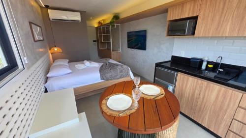 ein kleines Zimmer mit einem Bett und einem Holztisch in der Unterkunft Nawa Beach Residence by La Playa in Tamandaré