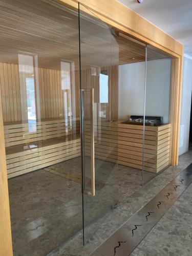 Una ducha de cristal en una habitación con paredes de madera. en Maison Poluc - Cadeau des Alpes, en Champoluc