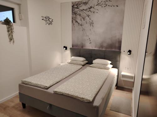 a bedroom with two beds and a painting on the wall at Apartman „Karolina” in Nova Gradiška