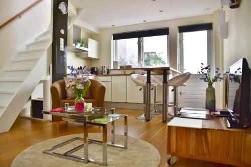 ein Wohnzimmer mit einer Treppe und einem Tisch in der Unterkunft Tannery Lane in Gouda