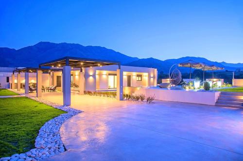 a villa with a view of the mountains at night at Haus In Georgioupoli Mit Außenpool Und Atemberaubender Aussicht in Kavros