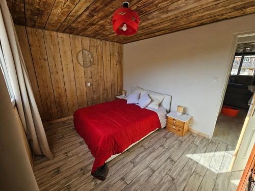 a bedroom with a red bed with a red blanket at Le ptit clos in Les Combes