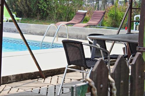 a table and chairs next to a swimming pool at Residencial Pinho Verde in Mealhada