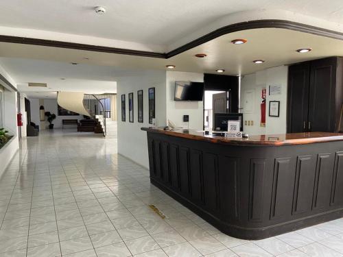eine große Lobby mit einer Bar in einem Gebäude in der Unterkunft Hotel María del Carmen in Jalpan de Serra