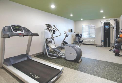 a gym with a treadmill and ellipticals in a room at WoodSpring Suites McKinney in McKinney