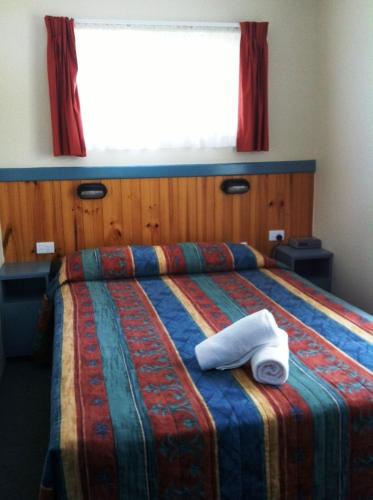 a bedroom with a bed with two towels on it at Edgewater Holiday Park in Port Macquarie