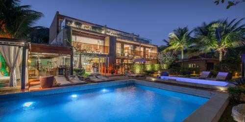 a house with a swimming pool in front of it at Hotel Spa Nau Royal in Camburi