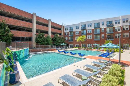 a swimming pool with lounge chairs and a building at Charming 1-bedroom apartment in terrific Frisco next to Toyota Stadium with WiFi & fitness in Frisco