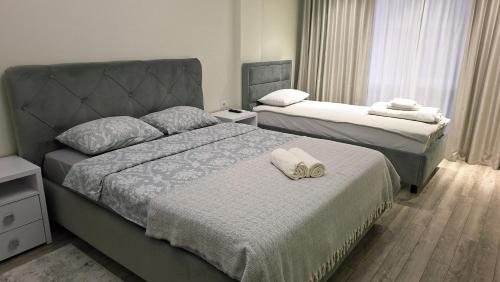 two beds in a hotel room with towels on them at Транзит Сервис 1 Аэропорт- Кишинёв in Chişinău