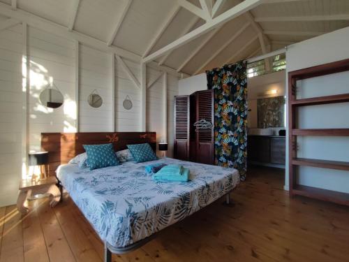a bedroom with a bed with a blue comforter at Villa Franco - Plage de Leroux à 600m - Vue mer exceptionnelle in Deshaies