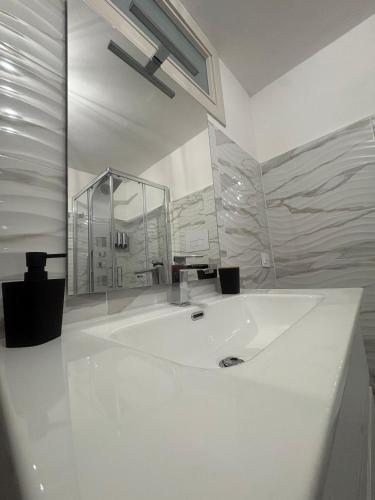 a white bathroom with a large sink and a shower at Residenza Stella in Isernia