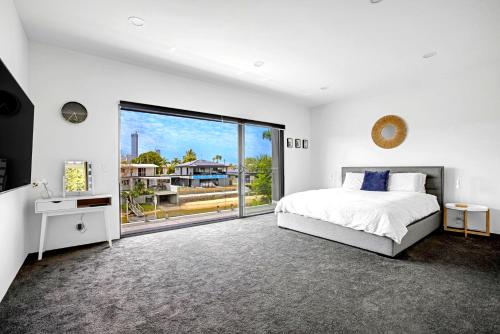 Un dormitorio blanco con una cama y una ventana grande. en Urban Hideaway Pet Friendly, en Gold Coast