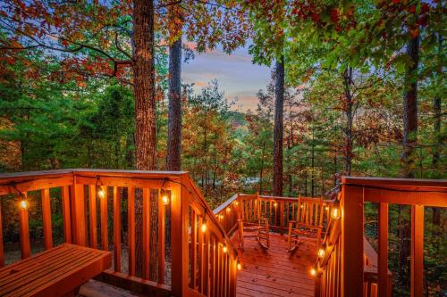 a wooden deck with lights and chairs on it at Secluded Views Kings Pets Games 75 TV in Sevierville