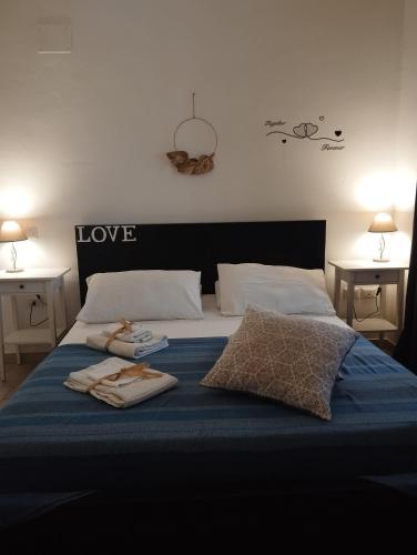 a bed with a blue blanket and two towels on it at La casetta di Jasmine in Salerno