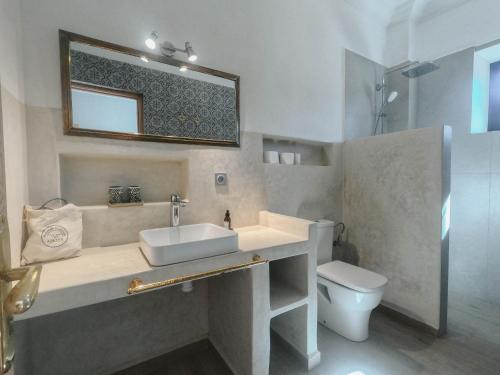 Un baño con lavabo, inodoro y espejo. en AdaZen Ecolodge, en Azilal
