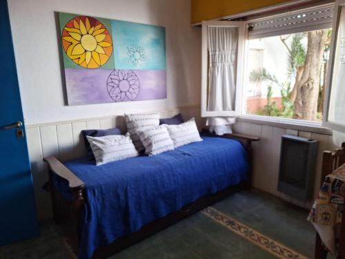 a bedroom with a bed with blue sheets and a window at La Vecindad del Sol Depto G in Miramar