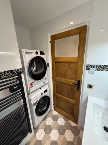 - une buanderie avec une porte et un lave-linge/sèche-linge dans l'établissement Appartement, à Saint-Michel-de-Maurienne