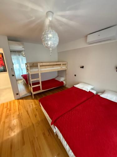 - une chambre avec un lit rouge et une couverture rouge dans l'établissement Appartement, à Saint-Michel-de-Maurienne