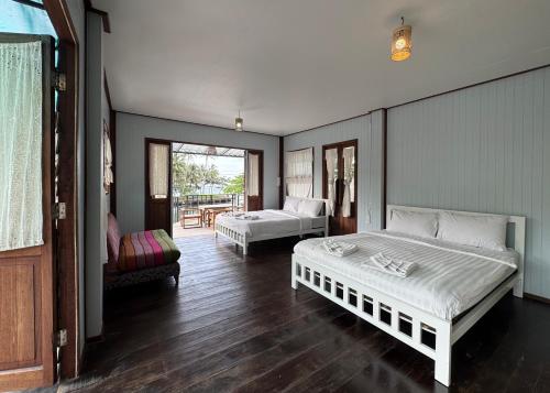 a bedroom with two beds and a balcony at คลองมาดโฮสเทลเกาะกูด Klongmad Hostel Kohkood 