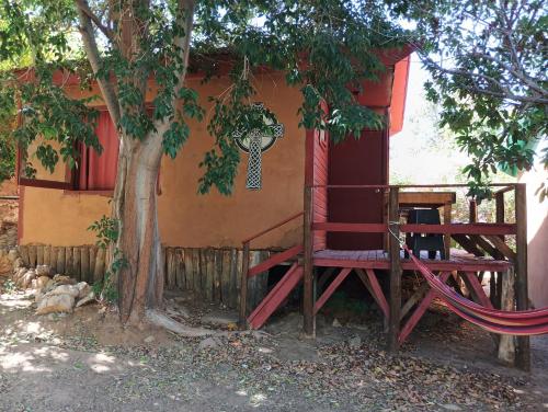 a tree house with a hammock next to a tree at Lodge Gabriela Mistral in Pisco Elqui