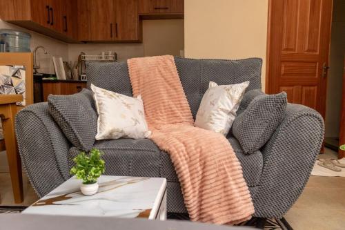 ナニュキにあるJAS Staysの灰色のソファ、枕2つ、毛布