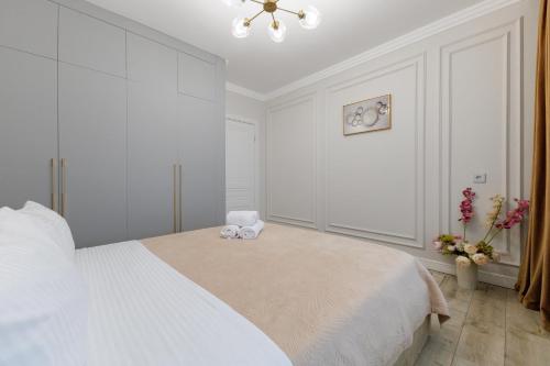 ein weißes Schlafzimmer mit einem Bett mit zwei ausgestopften Tieren darauf in der Unterkunft Шикарные апартаменты возле Хан Шатыр in Astana