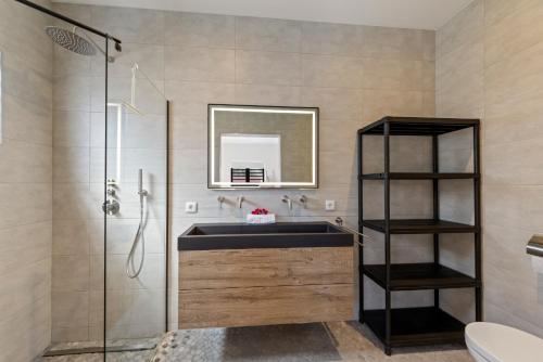 a bathroom with a sink and a glass shower at Casa Carpe Diem with private pool, Mambo Beach in Willemstad