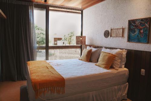 a bedroom with a large bed with a large window at Casa com piscina aquecida, cozinheira, 30m do mar in Barra do Camaragibe