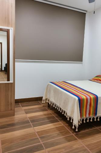 een kamer met een bed met een kleurrijke deken erop bij Condominio Alegre Amanecer in Santa Cruz Huatulco