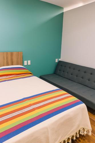 a bedroom with a bed with a rainbow blanket at Condominio Alegre Amanecer in Santa Cruz Huatulco