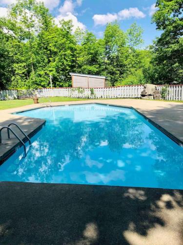 a swimming pool with blue water in a yard at A113 Loon Mountain Studio Apartment with Pool and Hot Tub in Lincoln