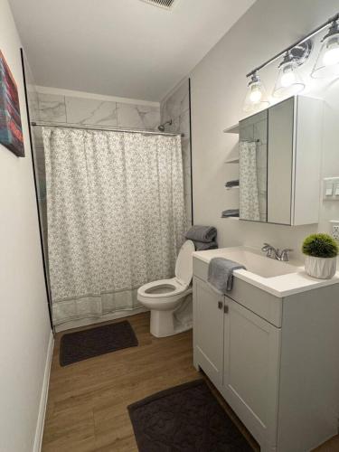 a bathroom with a toilet and a sink and a shower at Affordable Elegance Modern 2BR Getaway in London