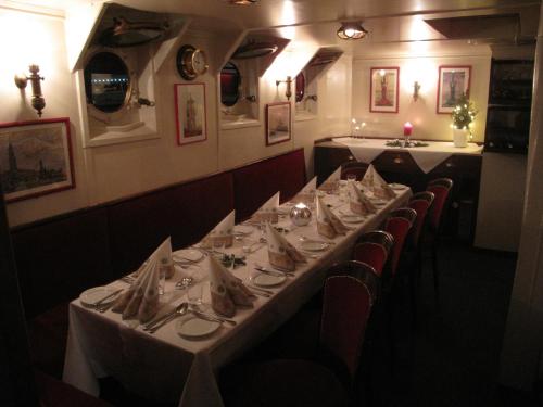 a dining room with a long table with white table cloth at Das Feuerschiff in Hamburg