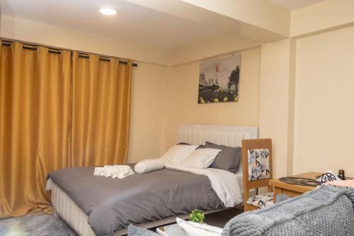 a bedroom with two beds in it with yellow curtains at JAS Stays in Nanyuki