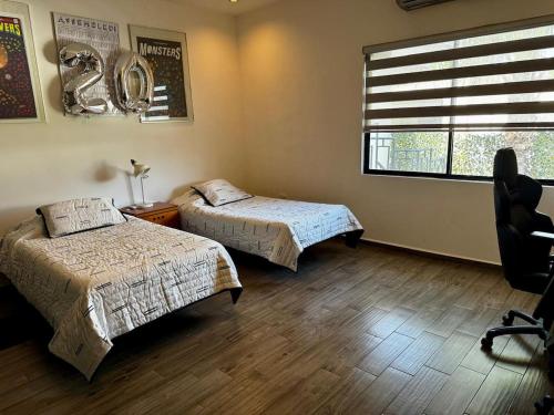 Un dormitorio con dos camas y una ventana en PLAZA VERANO, en Monterrey