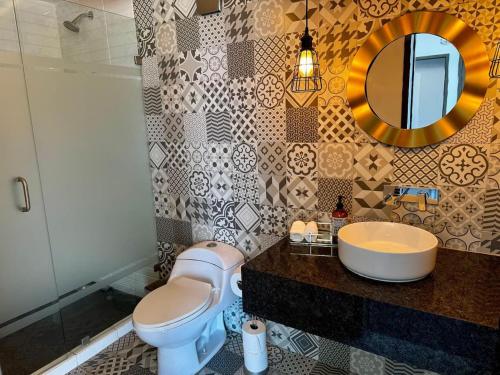 Un baño con lavabo, inodoro y espejo. en PLAZA VERANO, en Monterrey