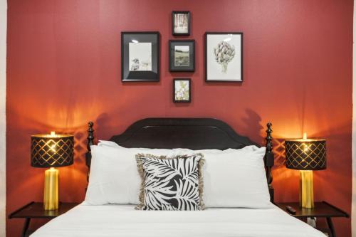 a bedroom with red walls and a bed with two lamps at The Larimar 2BD TownHouse 7ST Walkable in Fort Worth