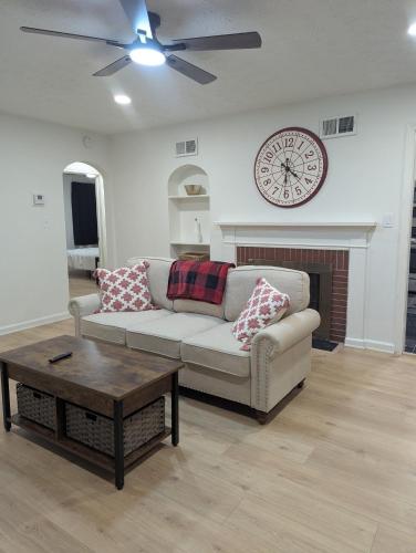 a living room with a couch and a clock on the wall at Oilgate at Parkgate in Akron