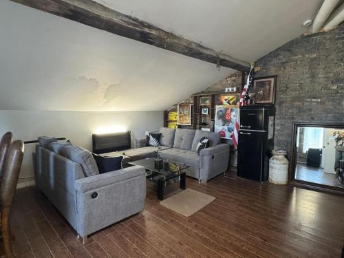 a living room with couches and a brick wall at Historic Downtown Apartment 2BD Retreat in London