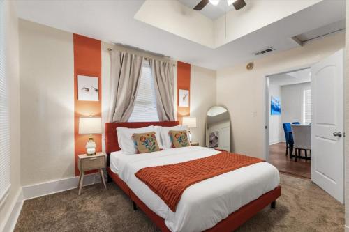 a bedroom with a large bed with orange and white walls at Uplifting 2BD House in the heart of FortWorth in Fort Worth