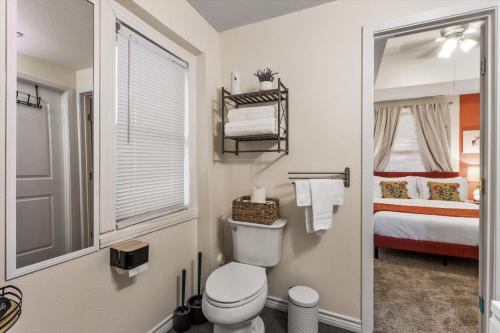 a bathroom with a toilet and a bed and a mirror at Uplifting 2BD House in the heart of FortWorth in Fort Worth