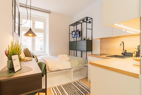 eine Küche mit einem Bett und einem Waschbecken in einem Zimmer in der Unterkunft Raciborska Old Town in Gliwice