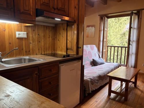 a kitchen with a sink and a couch in a room at Tranquilidad en apartamento rústico con parking - Aigüestortes 3 in Pla de l'Ermita