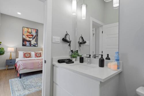 a white bathroom with a sink and a bedroom at A La mode 2BD Townhouse 7TH St walkable in Fort Worth
