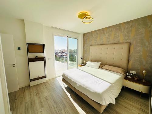 ein Schlafzimmer mit einem großen Bett und einem großen Fenster in der Unterkunft Casa Blanca in Torre del Mar
