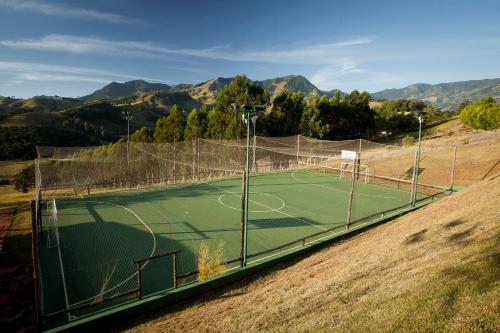 a tennis court in the middle of a field at Pousada do Quilombo in São Bento do Sapucaí